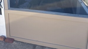 Una habitació amb un finestral gran, un llit, una cadira i una taula petita.