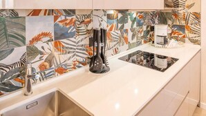 A kitchen with a white countertop, stainless steel sink, and a coffee maker. - Blue Lake Residence (Bardolino)