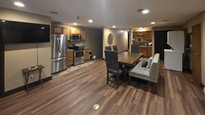 A modern kitchen with built-in appliances, a dining area with a table and chairs, and a flat-screen TV mounted on the wall. - Big space on Deadwood`s Main Street! (Deadwood)