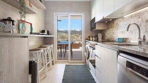 Una cocina moderna con lavavajillas, un fregadero y ventana con vistas a un patio.