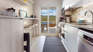 Een moderne keuken met een inbouwvaatwasser, een spoelbak en een eethoek met uitzicht.