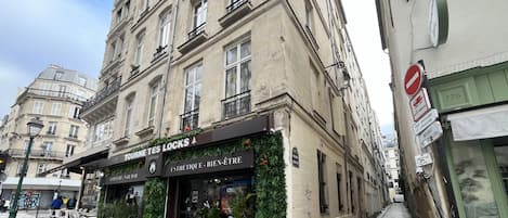 A building with a storefront named 'TOURNE TES LOCKS' and a sign for 'COIFFURE - NAIL BAR' below.