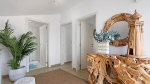 Un intérieur moderne agrémenté d’un élément central en bois, d’une plante en pot et d’un miroir.