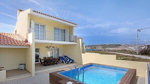 Un immeuble de deux étages doté d’une piscine, de mobilier d’extérieur et offrant une vue sur la ville.