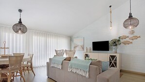 Un salon moderne comprenant un canapé, une table à manger, des chaises et une décoration murale représentant des poissons.