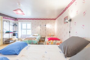 Ein Schlafzimmer mit zwei Betten, einem Kleiderschrank, einem Fenster und einer Tür.