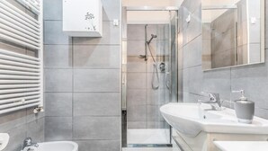 A modern bathroom with a shower, bidet, and two sinks. - Battistini Sweet House (Roma)