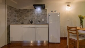 Eine moderne Küche mit Einbauherd, Kühlschrank und Essbereich mit Holztisch und Stuhl.