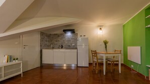 Eine kompakte Küche mit Essbereich, einem Einbauherd und einer Wand in Grünton.