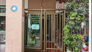 L'ingresso di un edificio con un cancello in metallo, una targa con la scritta 'ED. ASI' e una pianta in vaso.