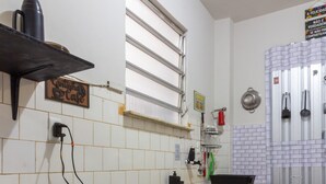 Una cucina compatta con piano cottura a gas, macchina del caffè e un piccolo tavolo da pranzo.