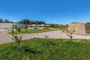 A restaurant with outdoor seating, a stone wall, and a clear blue sky. - Agricola Chiani | Camera Familiare (Melendugno)