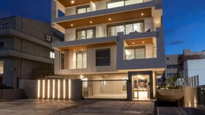 Een meerlaags hotel met balkons, een hekpoort en een modern architectonisch ontwerp.