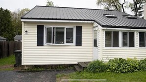 Ett envåningshus med ett sadeltak, en veranda och ett garage.