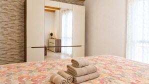 A hotel room with a bed, a mirror, and a wardrobe. - Nonna Lucia apartment: comfort and relaxation in Lotzorai (Lotzorai)