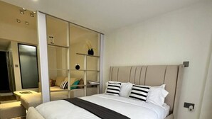 Un dormitorio moderno con una cama grande, armario empotrado y mesita de noche.