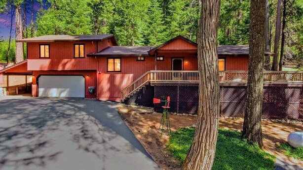 A two-story wooden cabin with a garage, surrounded by trees. - Cozy 2-bedroom cabin in Pollock Pines, Apple Hill/Gold Country (Pollock Pines)