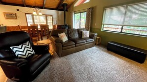 A cozy living room with a leather sofa, a black armchair, and a wooden ceiling. - Cozy 2-bedroom cabin in Pollock Pines, Apple Hill/Gold Country (Pollock Pines)