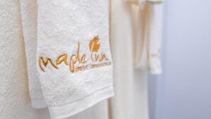 A white towel with 'Maple Inn' embroidered in gold. - maple Inn Hotel (Ruiru)