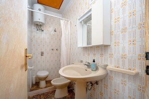 A bathroom with a toilet, bidet, sink, and shower. - Apartment 'Villa Burdi' with Sea View, Private Terrace and Air Conditioning (Capitolo)