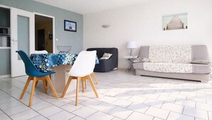 Un salon moderne comprenant un coin repas, un canapé et une lampe.