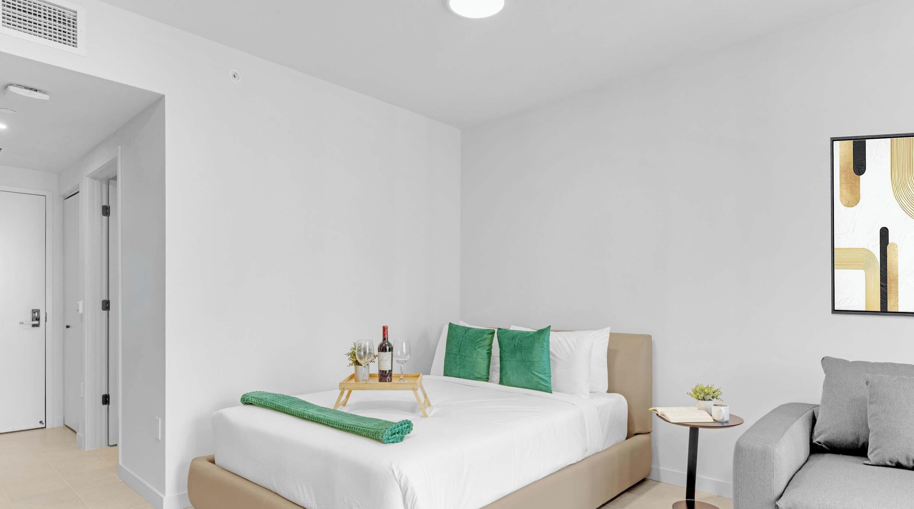 Ein modernes Hotelzimmer mit Bett, Nachttisch und einer kleinen Sitzecke.
