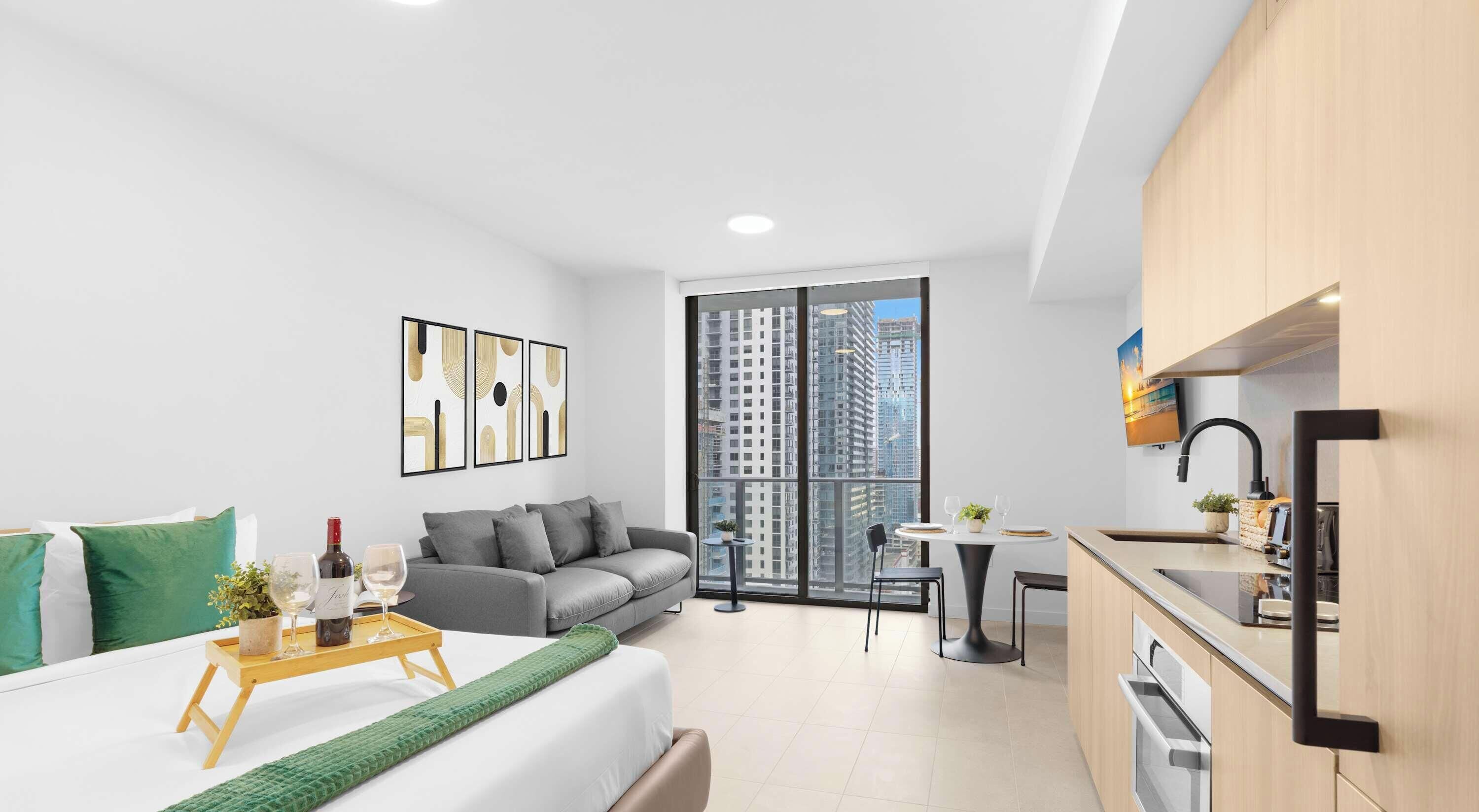 A modern apartment with a balcony, a dining area, and a kitchenette.