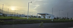 A modern building with a flat roof, surrounded by a well-maintained grassy area and street lamps. - Lizzie’s Home 2-bedroom house with AC in pleasant San Miguel (san miguel)