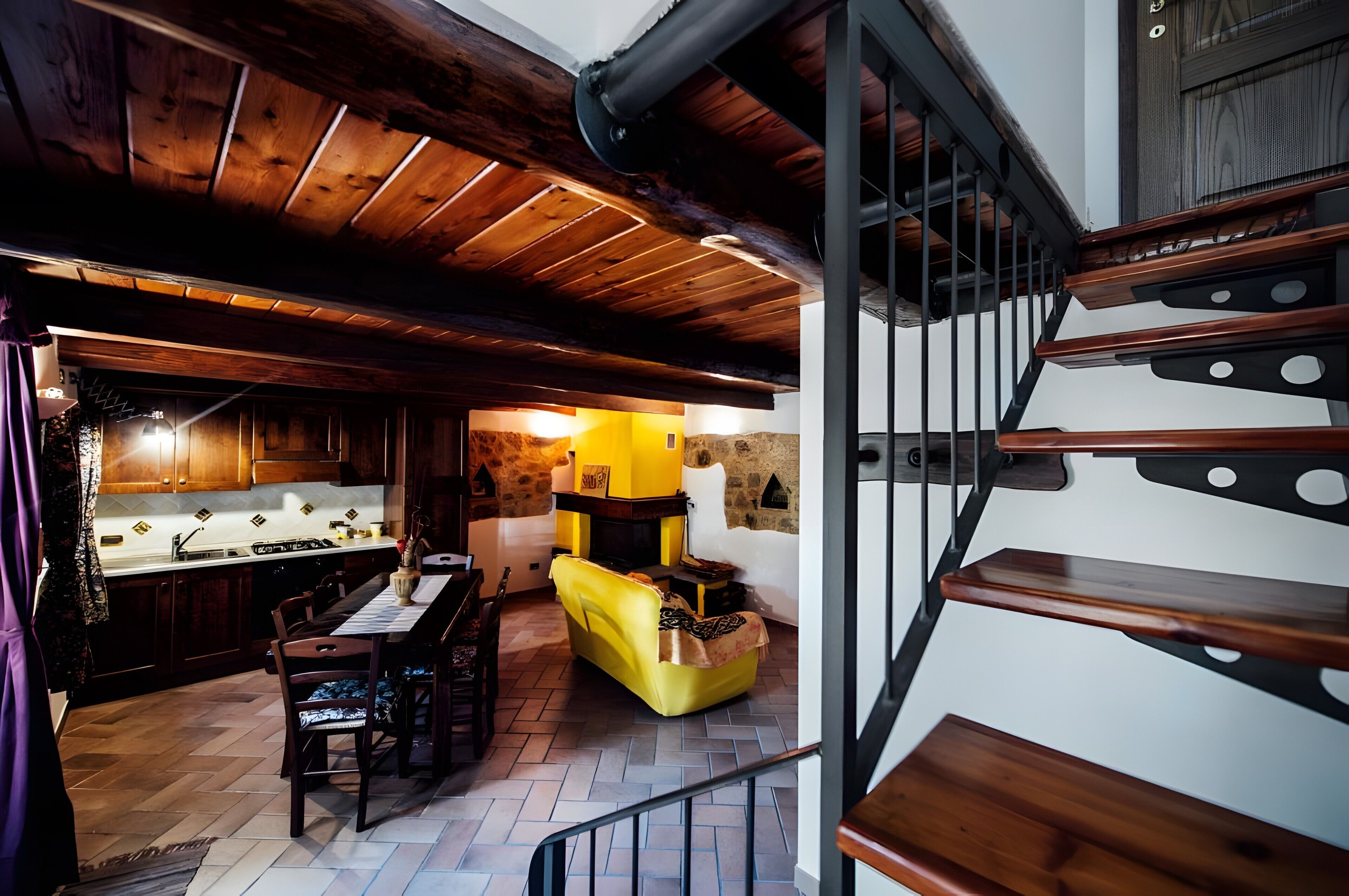 A wooden interior with a dining area, kitchen, and a staircase.