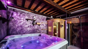 Un jacuzzi con una cabaña de madera y una pared de piedra.