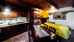 Una cocina con armarios de madera, una estufa y un sofá amarillo.