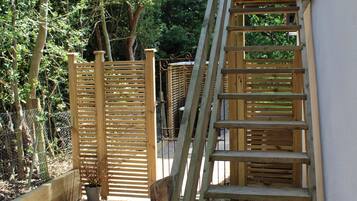 Una escalera de madera al aire libre que sube hacia un edificio.