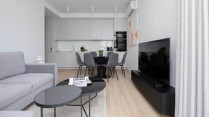 A modern living room with a sofa, a coffee table, and a TV. - Comfortable Apartment | Parking | Remote Work (Warszawa)