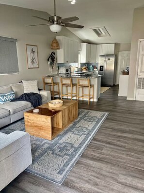 Una sala de estar moderna con un sofá, una mesa de centro de madera y un tapete estampado.