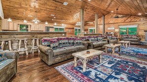 A spacious log cabin interior with a large living area, a kitchen with wooden cabinets, and a dining area. - Lakefront - Private Lake Retreat with INGROUND POOL! (Sevierville)