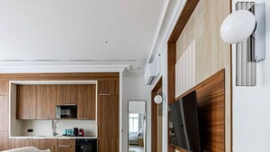 A modern living room with a sofa, a coffee table, and a TV mounted on the wall. - Suite luxueuse-le Marais - Châtelet-Paris 3#AC (Paris)