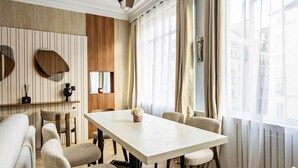 A modern dining area with a long table, cushioned chairs, and a wooden floor. - Suite luxueuse-le Marais - Châtelet-Paris 3#AC (Paris)