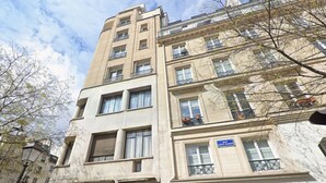 A multi-story building with balconies, a sign reading 'Rue Saint Martin,' and a street lamp. - Suite luxueuse-le Marais - Châtelet-Paris 3#AC (Paris)