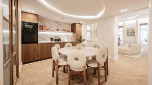 Une cuisine moderne dotée d’un four à micro-ondes et d’un four encastrés, d’un meuble en bois et d’un pare-feu en marbre.
