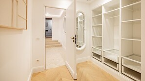 Un couloir avec un placard, une porte donnant sur une autre pièce et un escalier.