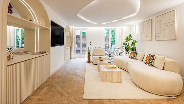 Un salon moderne avec un canapé, une table basse et un téléviseur.