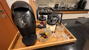 A coffee maker, a coffee mug, a glass jar, and a tray with a coffee sign in a kitchen setting. - Studio novo  Uberlândia (Uberlândia)