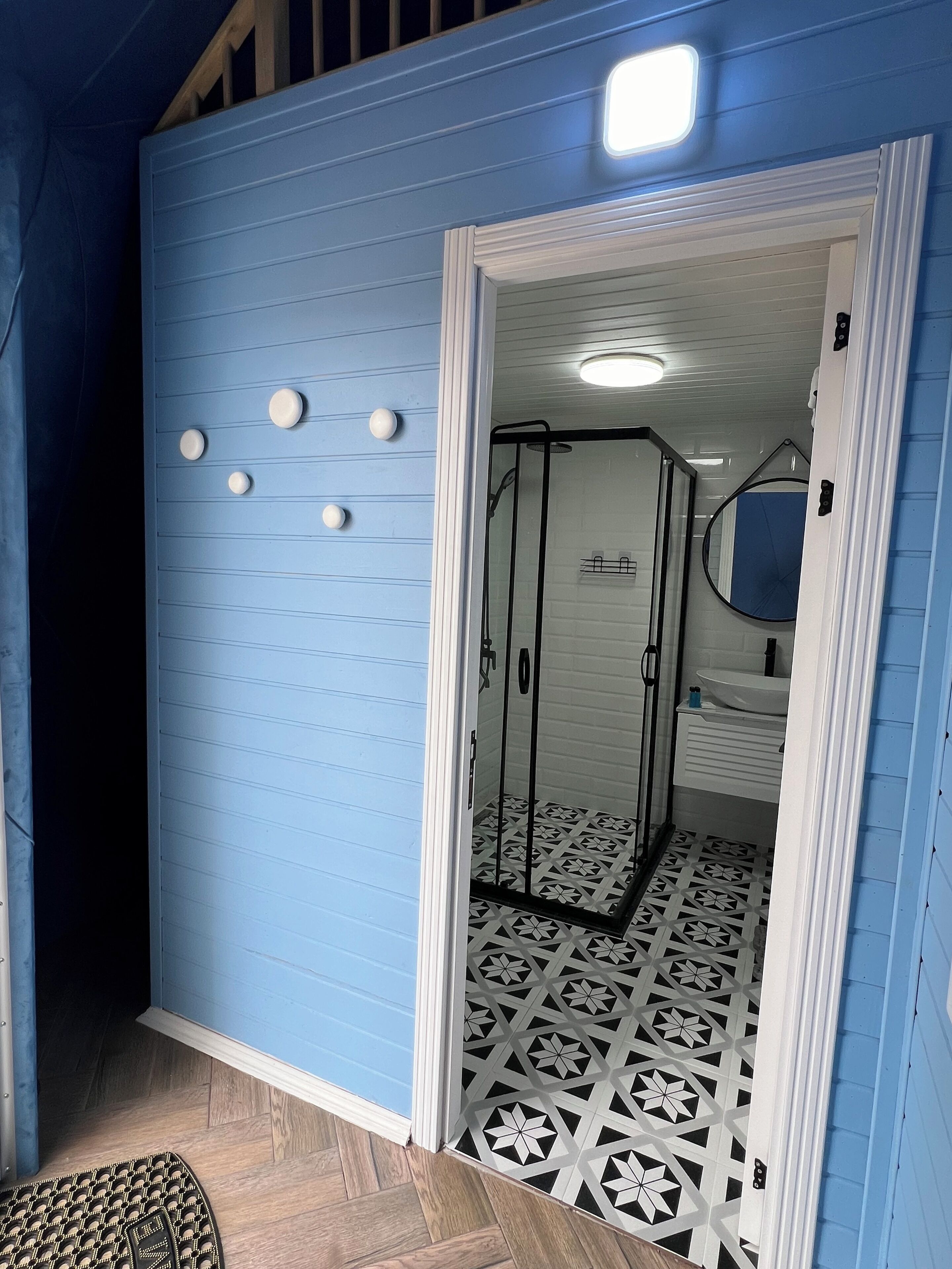 Un baño con ducha, lavamanos y espejo.