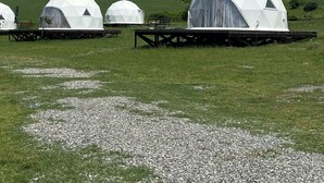 Geodesic dome structures in a grassy field with a mountainous backdrop. - Chadir yurd glamp (Ismailli)