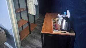 A room with a wooden table, a kettle, glasses, and a shelf with a white robe. - Chadir yurd glamp (Ismailli)