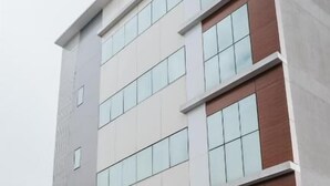 A multi-story hotel with a prominent 'HOTEL' sign, large windows, and a brick facade. - HOTEL GOLDEN INN (Conselheiro Lafaiete)