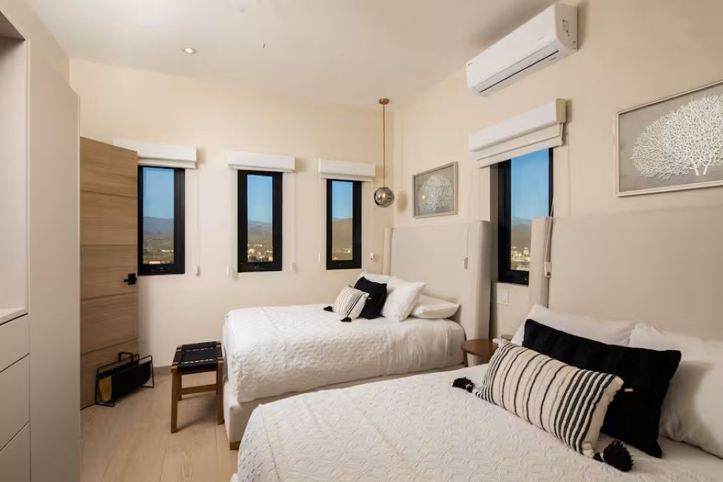 Une chambre d’hôtel avec deux lits, un bureau et une vue sur la ville.
