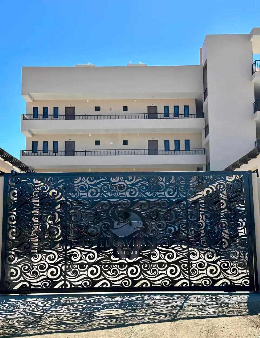 A gated entrance with intricate metalwork and the name 'EL CAVILAN VILLAS' visible.
