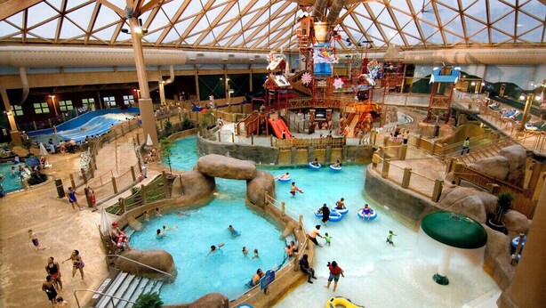 An indoor water park with multiple pools, slides, and play structures. - Moonlight Mountain Lodge at Camelback Mountain! (Tannersville)