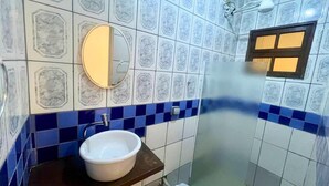 A bathroom with a white sink, a mirror, and a shower. - VEREDA 7 SUITES (São Sebastião)